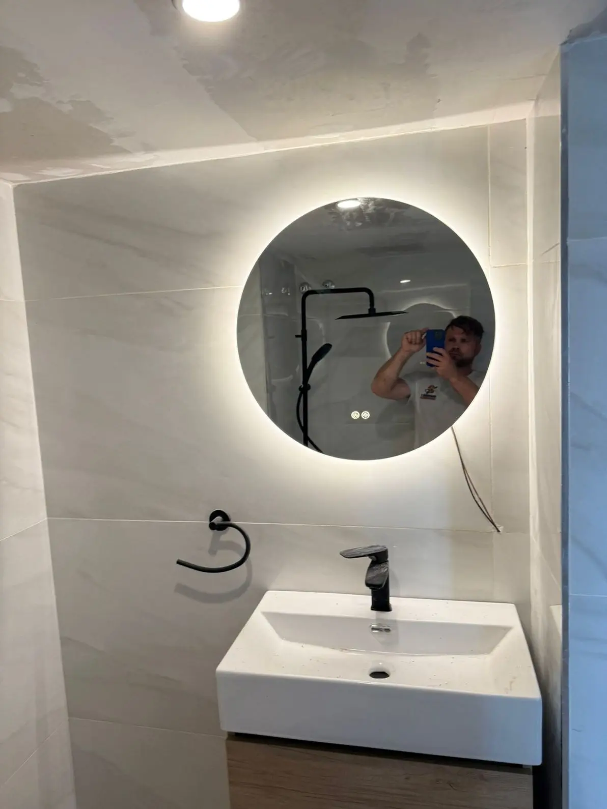 Reforma de baño completada con espejo LED y acabados modernos